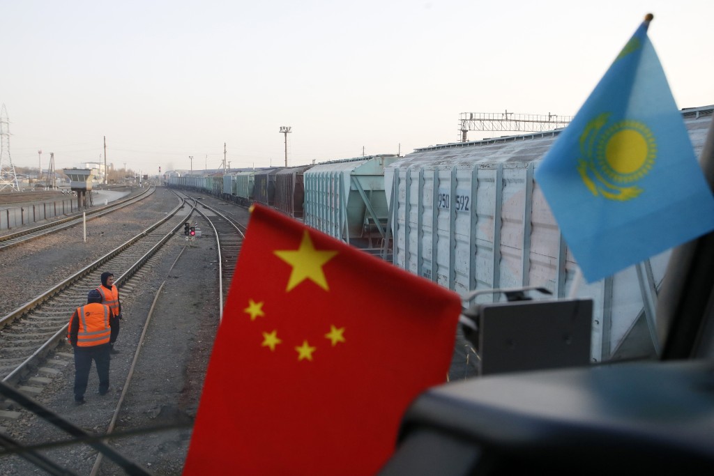Flags of China and Kazakhstan sit in the cabin of a locomotive at the railway station of Dostyk at the Kazakh-Chinese border, a key hub for trade between China and Europe through Central Asia, on November 18, 2025. (Photo by Ruslan PRYANIKOV / AFP)