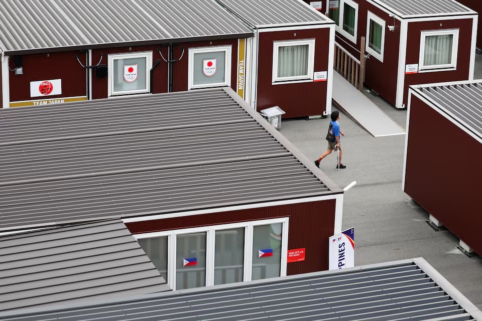 A person walks near wooden container units built to house athletes, including those for Japanese and Filipino athletes, ahead of the Aichi-Nagoya 2026 Asian Games in Nagoya, Japan, September 15, 2026. REUTERS/Edgar Su