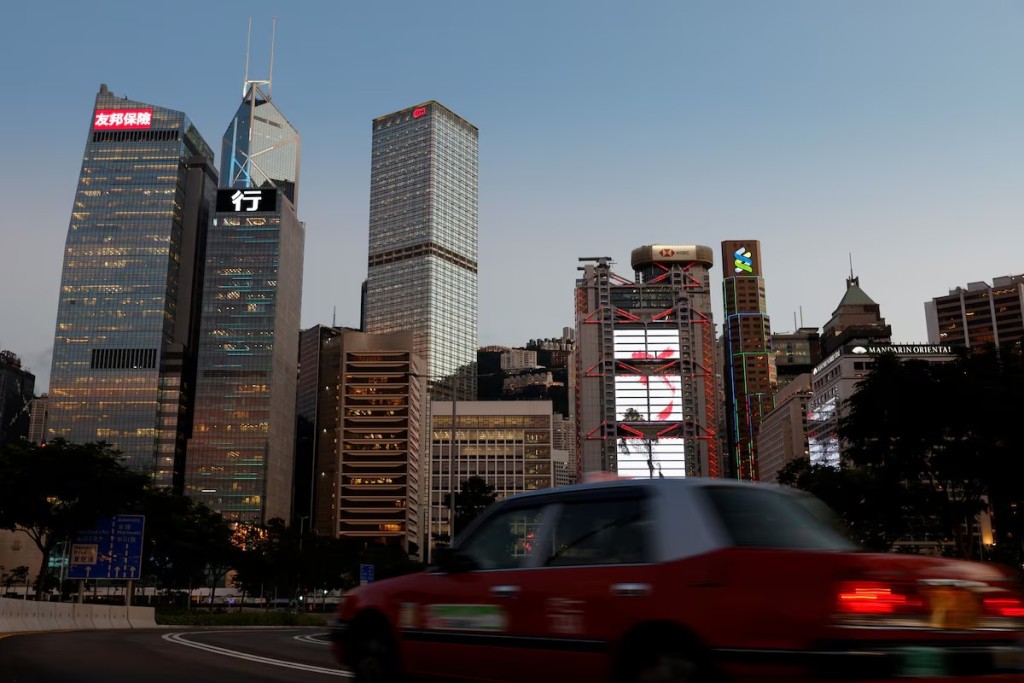 A taxi drives in front of skyscrapers at the central business district, including AIA Central, China Construction Bank (CCB) Tower, Bank of China Tower, Cheung Kong Centre, HSBC and Standard Chartered Bank headquarters, in Hong Kong, China August 17, 2021. REUTERS
