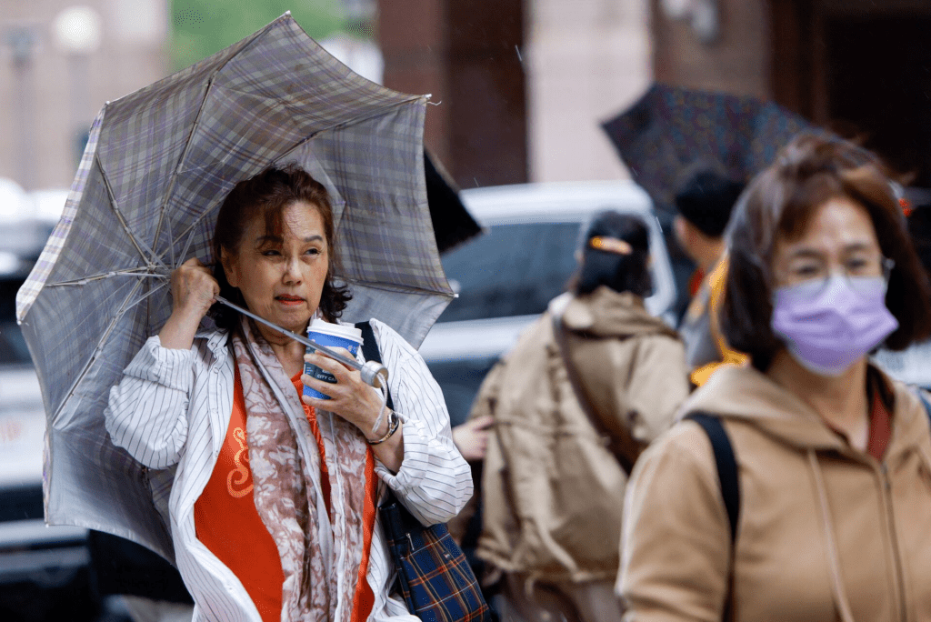 A woman holds her umbrella amidst strong winds and rain as Typhoon Fung-wong approaches, in Taipei, Taiwan, November 11, 2025. REUTERS/Ann Wang 