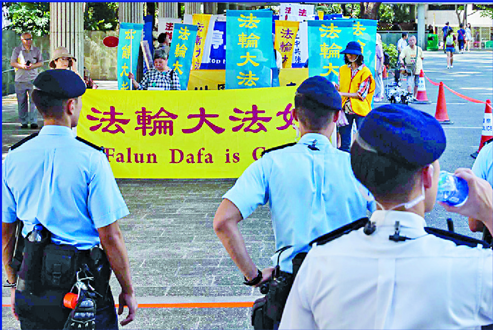 Police stand guard as Falun Gong members asks for support for a rally in Central in 2017. BLOOMBERG Police stand guard as Falun Gong members asks for support for a rally in Central in 2017. BLOOMBERG