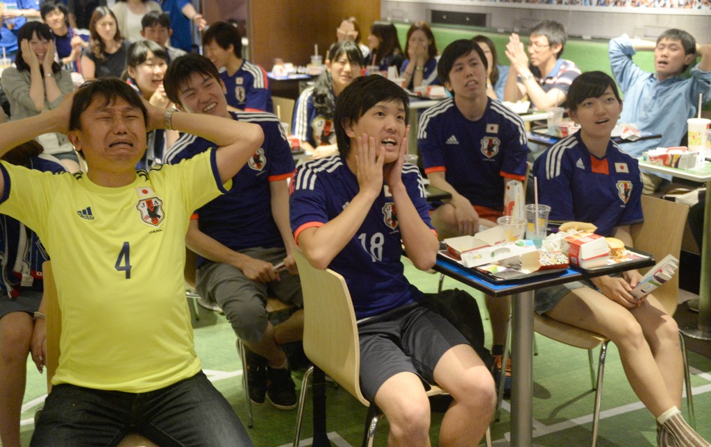 Photo by TORU YAMANAKA / AFP  Japanese football fans react after the second goal by Ivory Coast against Japan as they watch TV during the the group C first round match of the 2014 FIFA World Cup in Tokyo on June 15, 2014.