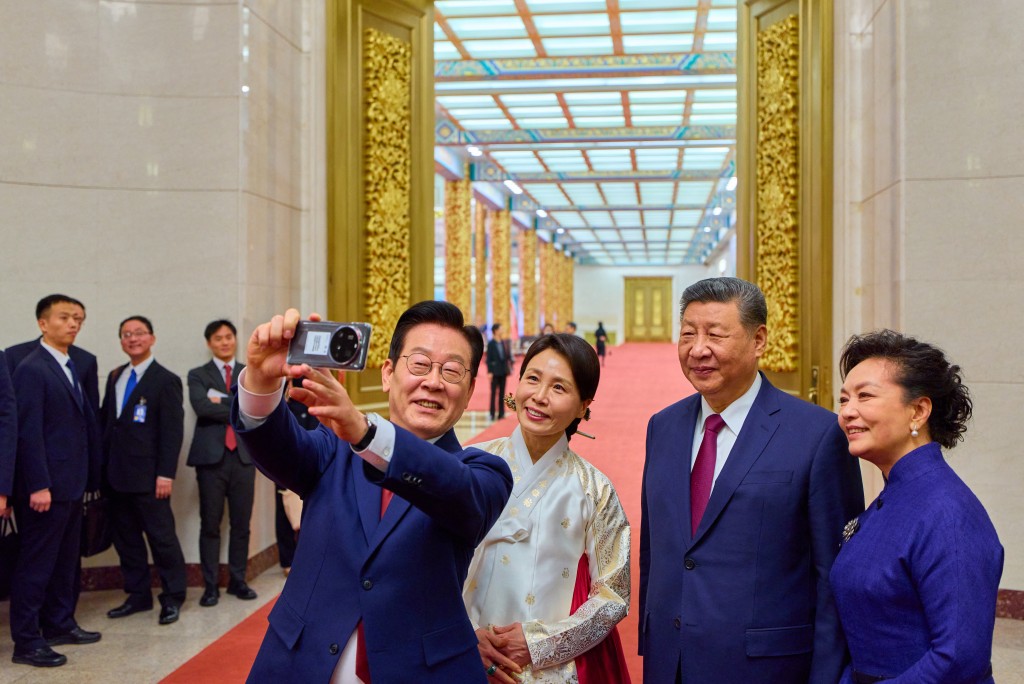 South Korea's President Lee Jae Myung (L) and his wife Kim Hea Kyung (2nd L) take a selfie with China's President Xi Jinping (2nd R) and his wife Peng Liyuan (R) after a dinner at the Great Hall of the People in Beijing on January 5, 2026. (AFP)