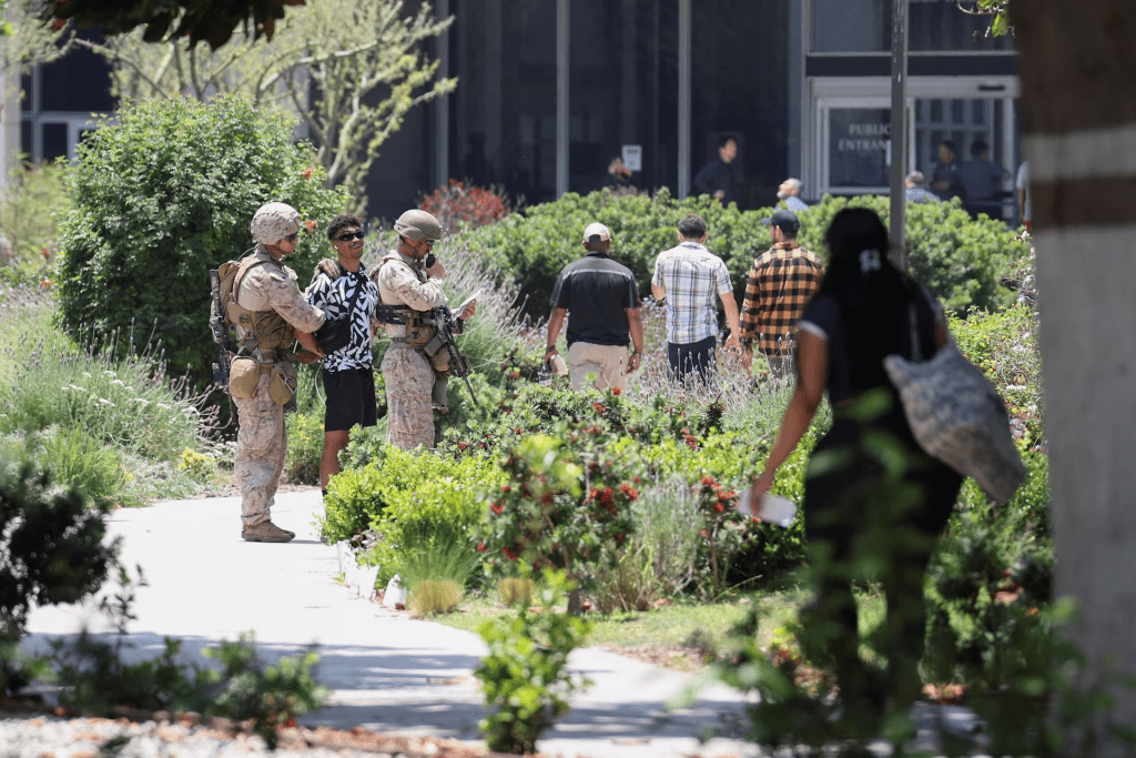 U.S. Marines detain a person outside the Wilshire Federal Building after Marines were deployed to Los Angeles, as protests against federal immigration sweeps continue, in Los Angeles, California, U.S. June 13, 2025. REUTERS/Aude Guerrucci 