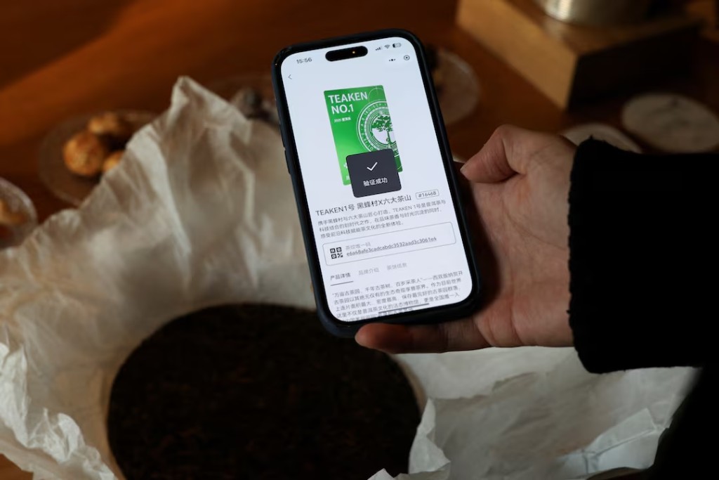 Eric Ma, founder and CEO of Teaken, scans a tea cake with the smartphone application at Bei Teahouse in Shanghai, China, December 15, 2025. REUTERS/Go Nakamura