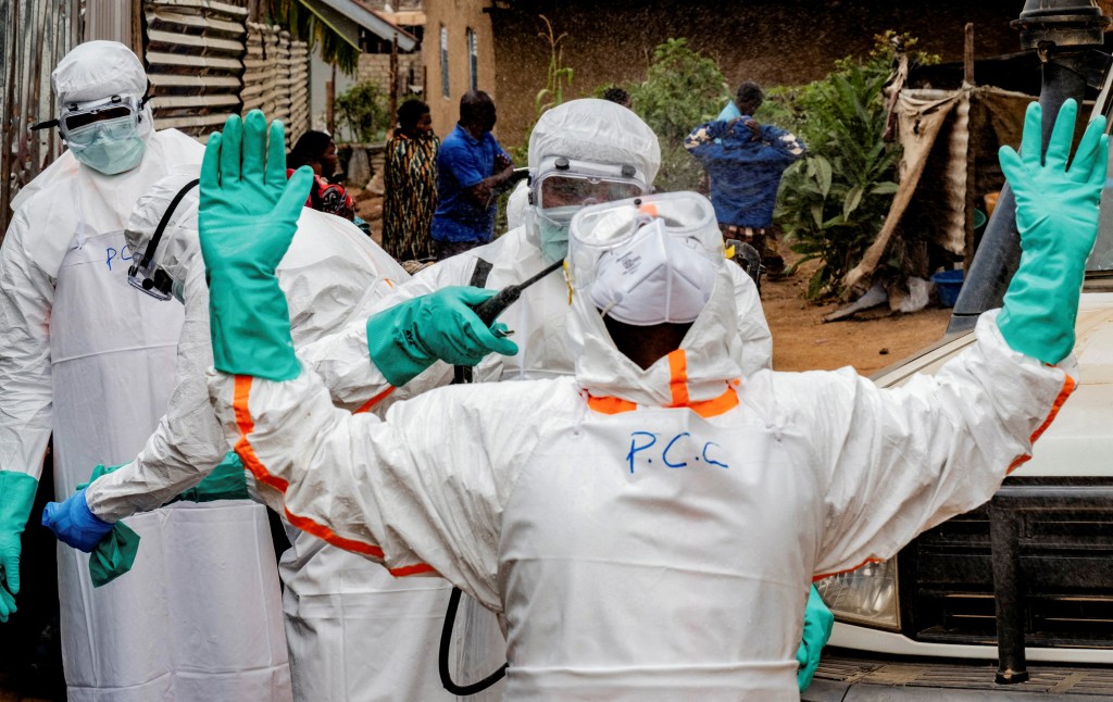 Members of the Civil Protection team, which works to help mitigate the spread of the Ebola virus, wearing personal protective equipment (PPE), disinfect after handling the body of an unidentified man, who according to his family, died of Ebola, in Bunia, Ituri province, Democratic Republic of Congo. (Reuters)