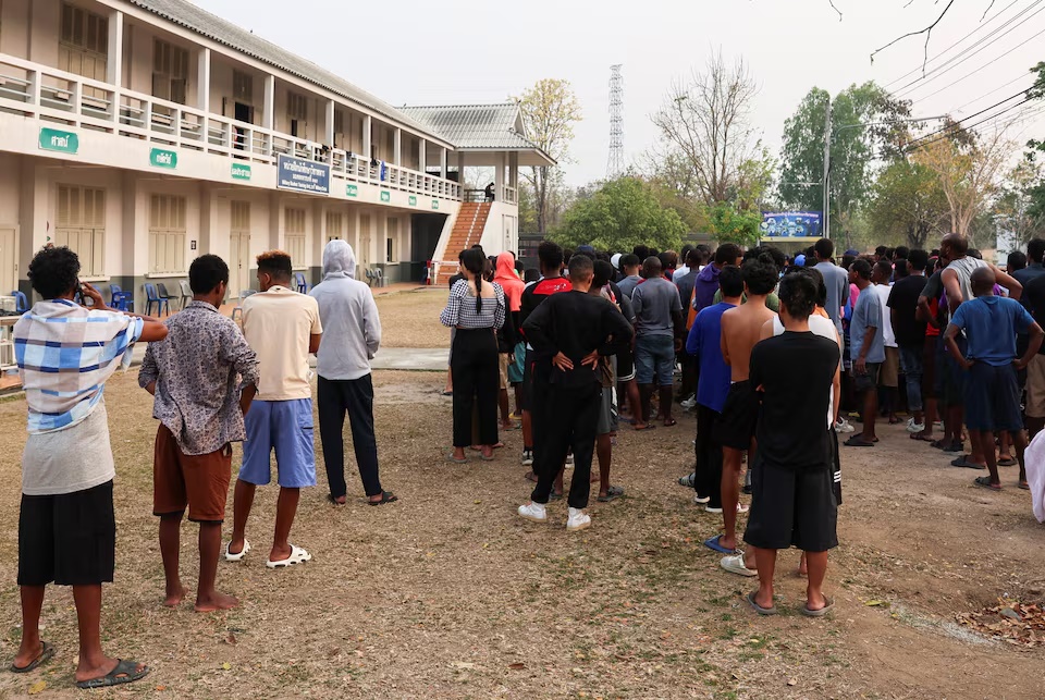 Multinational victims of scam centres, who were trafficked into working in Myanmar and were sent to Thailand on February 12 amid a mounting crackdown on scam centres operating along a porous border, queue to get food at a shelter inside the 310th Military District (Fort Wachiraprakan), as they wait for their embassies to pick them up, in Tak province, Thailand February 19, 2025. REUTERS/Chalinee Thirasupa