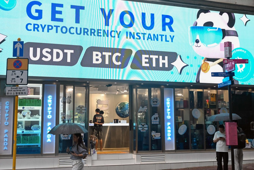 Bitcoin, ethereum and the stablecoin USDT are promoted at a cryptocurrency store in Hong Kong on July 29, 2025. (Photo by Peter PARKS / AFP)