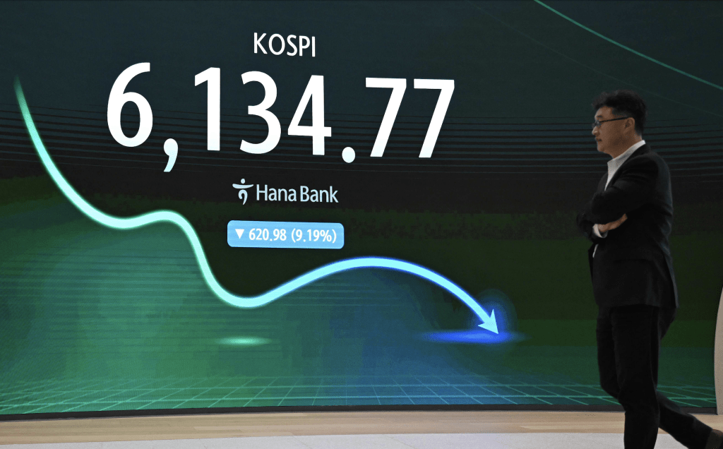 A man walks past an electronic screen showing South Korea's benchmark stock index (KOSPI) in a foreign exchange dealing room at the Hana Bank headquarters in Seoul on July 28, 2026. Japanese and Korean shares dived in early trade on July 28, after US semiconductor chip stocks fell following a report of a breakthrough that could boost China's computer chip industry. (Photo by Jung Yeon-je / AFP)