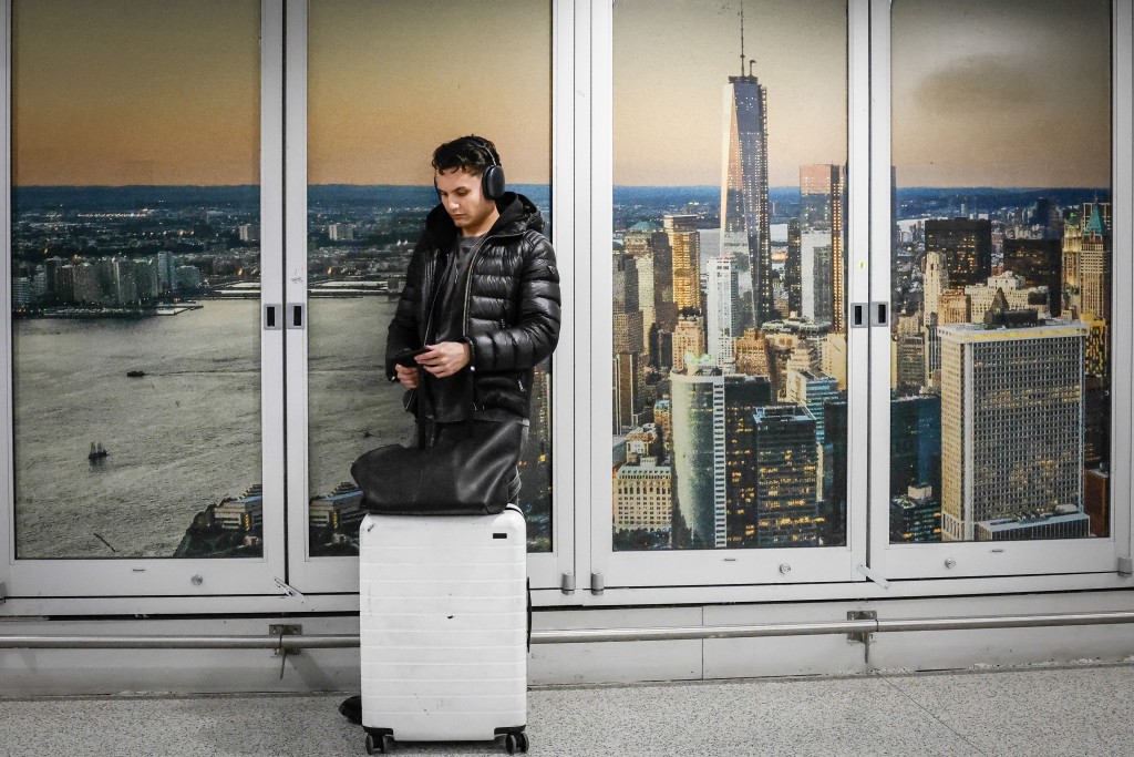 Photo by KENA BETANCUR / AFP  A traveller waits for his flight at Newark Liberty International Airport in Newark, New Jersey, on March 18, 2026.