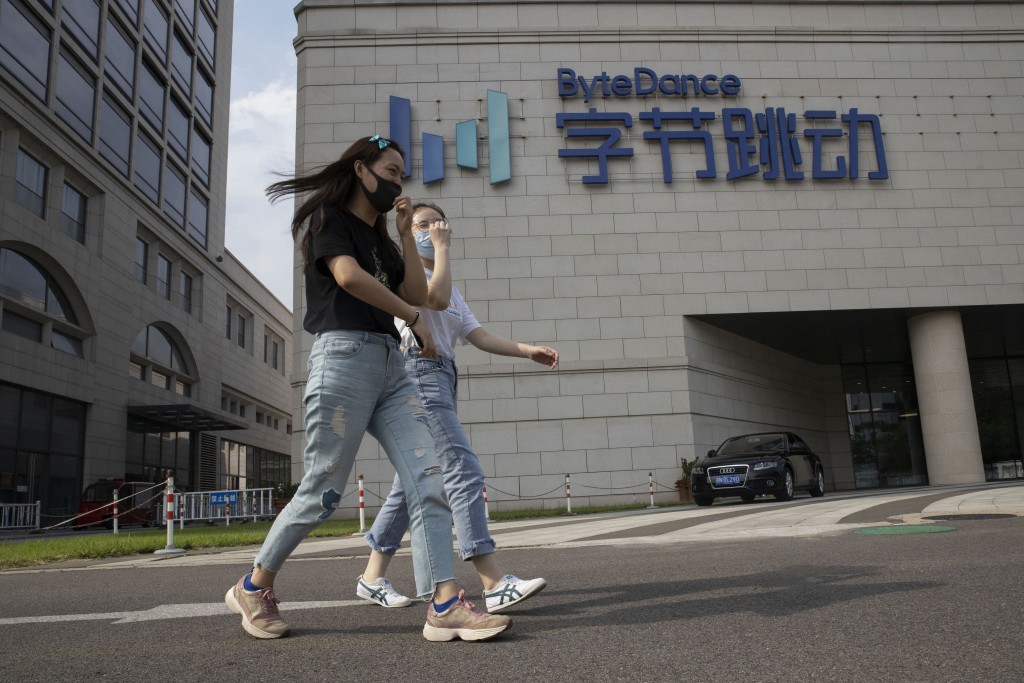 Women wearing masks to pass by the headquarters of ByteDance, owners of TikTok, in Beijing, China, Aug. 7, 2020. (AP Photo/Ng Han Guan, File)