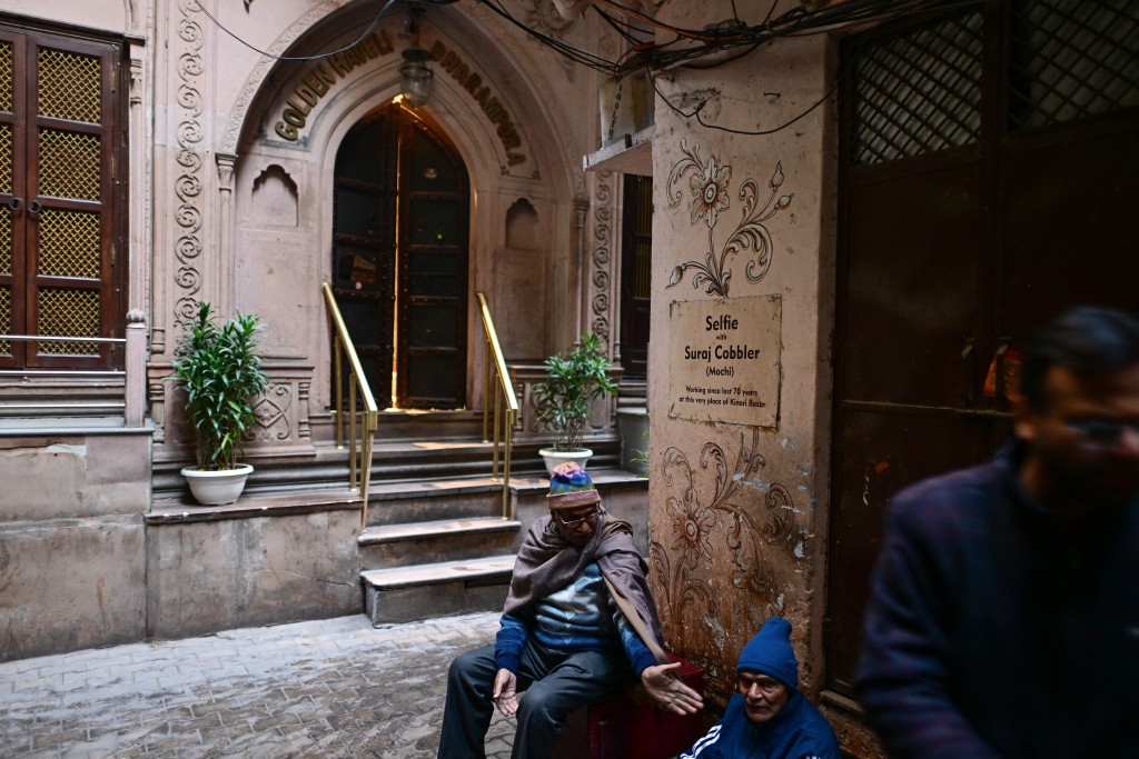 Photo by MANAN VATSYAYANA / AFP  This photograph taken on February 2, 2026 shows people sitting outside the Golden Haveli, an 18th-century haveli-turned-heritage hotel in the old quarters of Delhi.