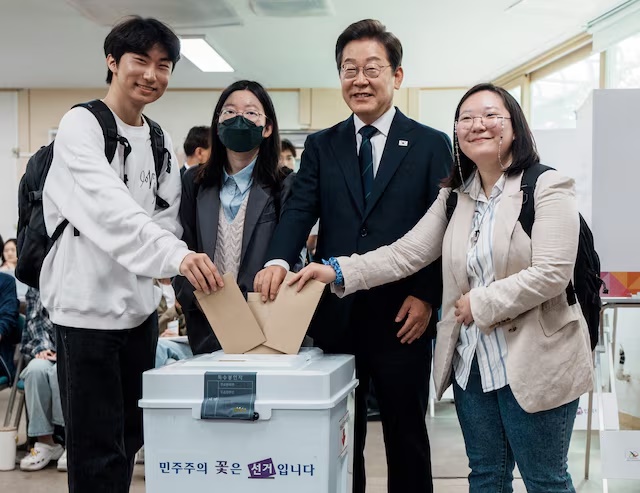 Lee Jae-myung, the presidential candidate for South Korea's Democratic Party, poses for photographs as he casts his early vote for the upcoming presidential election with his supporters at a polling station in Seoul, South Korea, May 29, 2025. Yonhap via REUTERS P