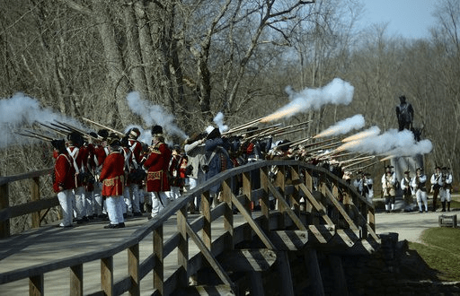 FILE - Acton Minutemen and British soldiers fire a ceremonial volley from the North Bridge, after the re-enactment of the North Bridge fight marking the 241st anniversary of the start of the American Revolutionary War, Monday, April 18, 2016, in Concord, Mass. (John Walker/The Metro West Daily News via AP,File)[ASSOCIATED PRESS/John Walker]