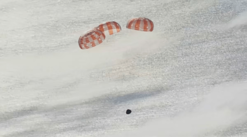 Three main parachutes deploy on the Artemis II crew capsule in this screengrab from a livestream video as it descends toward splashdown following its re‑entry to Earth after the Artemis II crew's flyby of the Moon, April 10, 2026. NASA/Handout via REUTERS