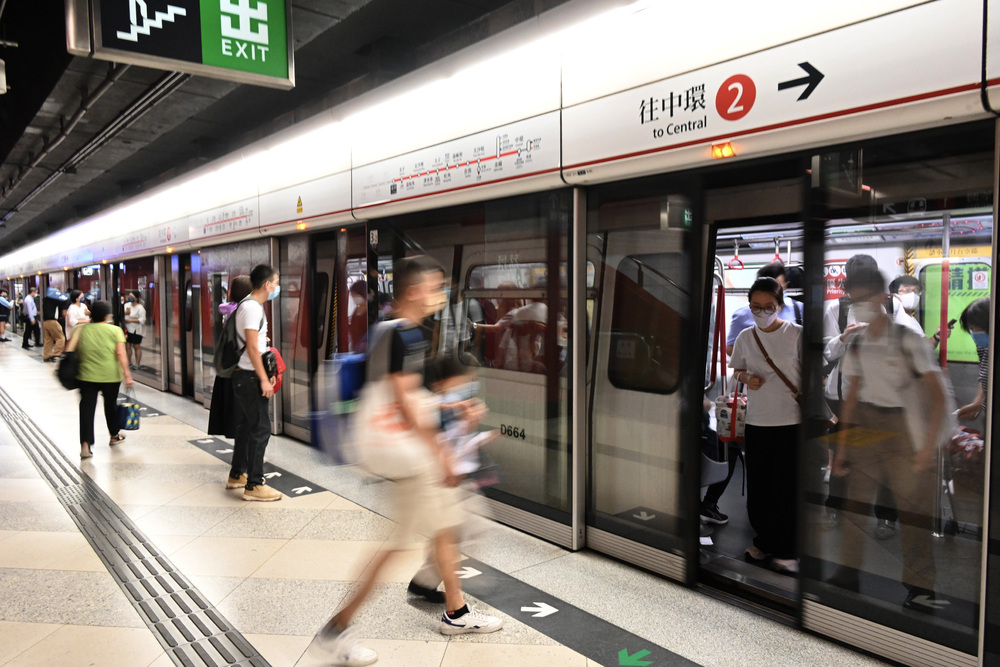 Passengers mind the gap yesterday at the spot where doors that had been ripped off could be seen on Sunday. The initial probe points to fencing parts, far left, leading to the partial derailment, says Lam Sai-hung.SING TAO