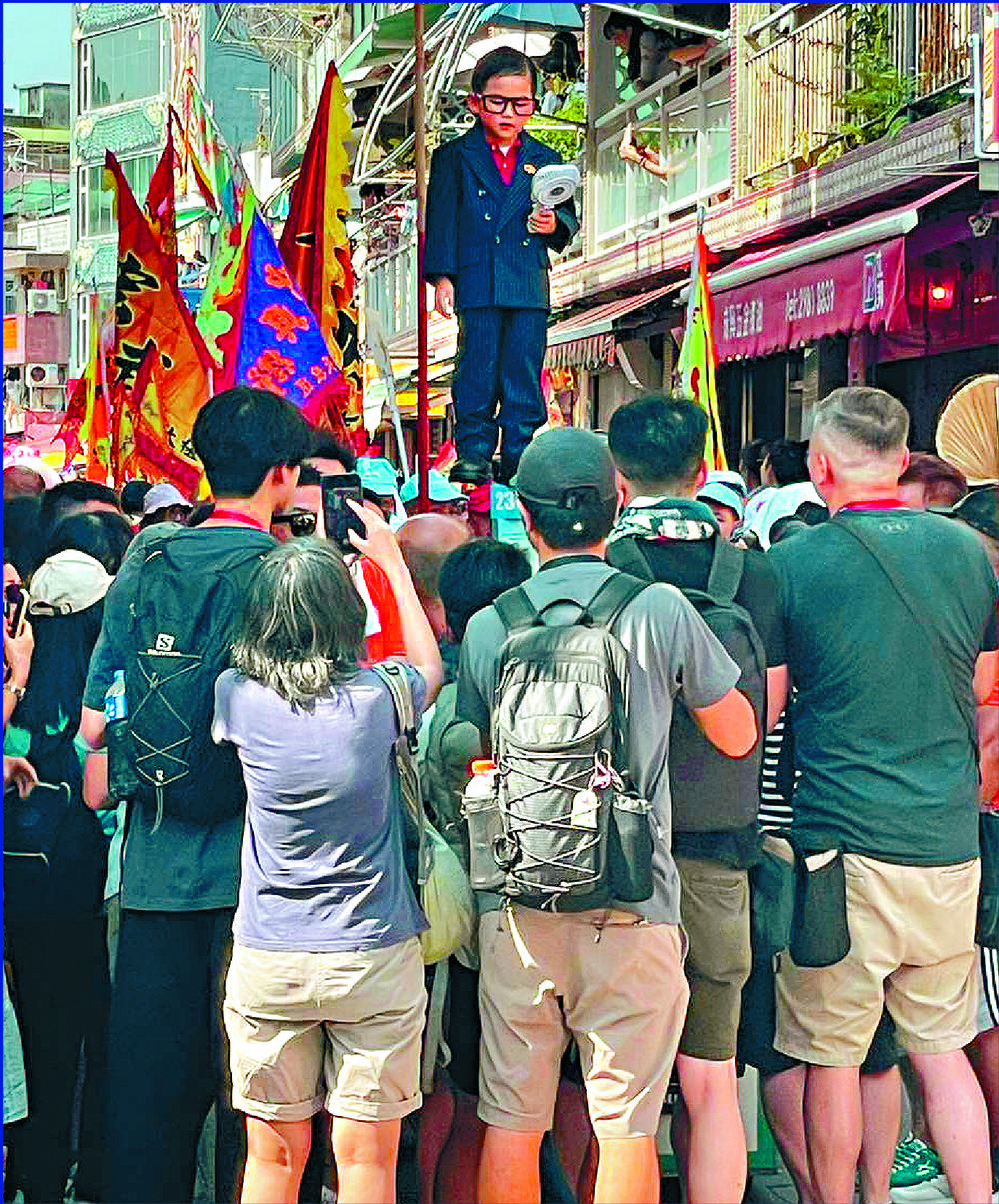 Crowds show their love for participants, including one dressed as Secretary of Security Chris Tang. SING TAO