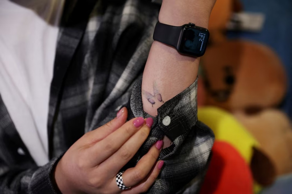  Nini Lee, a South Korean fan of the K-pop boy band BTS shows up a butterfly tattoo which is dedicated to the BTS song "Butterfly" during an interview with media at a cafe featuring BTS goods in Seoul, South Korea, June 15, 2022. REUTERS/Kim Hong-Ji/File Photo 