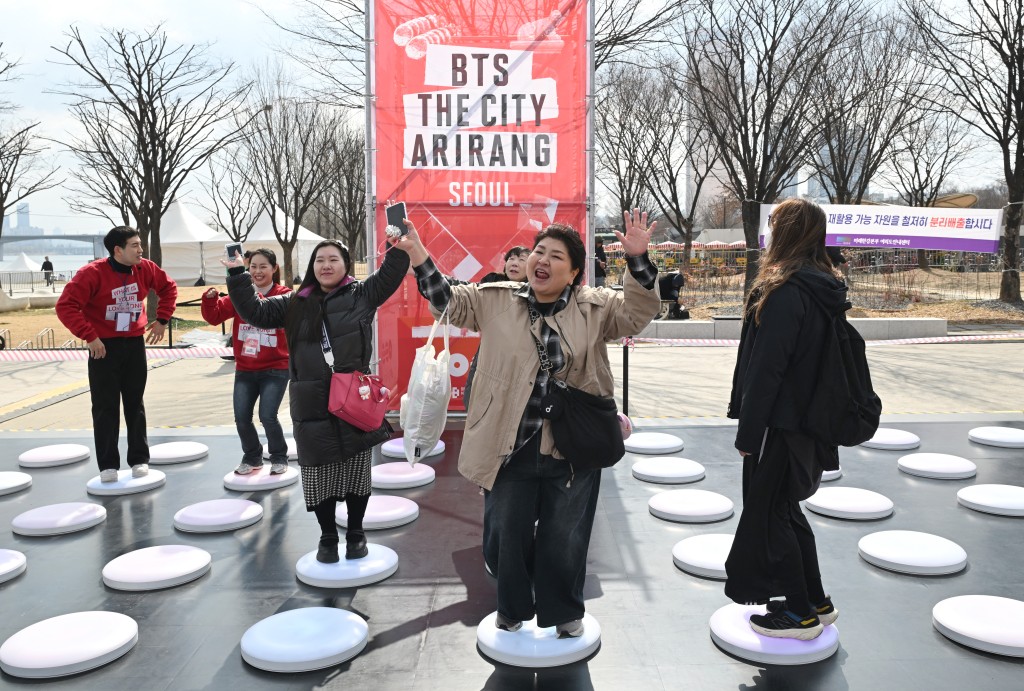 Photo by JUNG YEON-JE / AFP  BTS fans enjoy themselves at a fan zone promoting the new album of K-pop boy band BTS at a riverside park in Seoul on March 20, 2026.