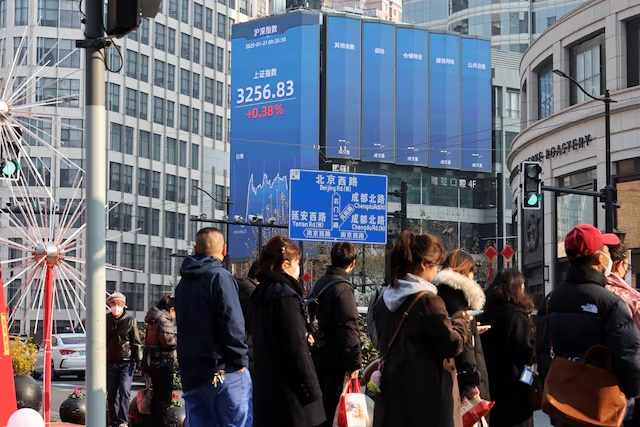 Pedestrians wait for a street signal on a sidewalk as an electronic billboard shows the Shanghai stock index in Shanghai, China January 21, 2025. REUTERS/Go Nakamura/File Photo Pedestrians wait for a street signal on a sidewalk as an electronic billboard shows the Shanghai stock index in Shanghai, China January 21, 2025. REUTERS/Go Nakamura/File Photo