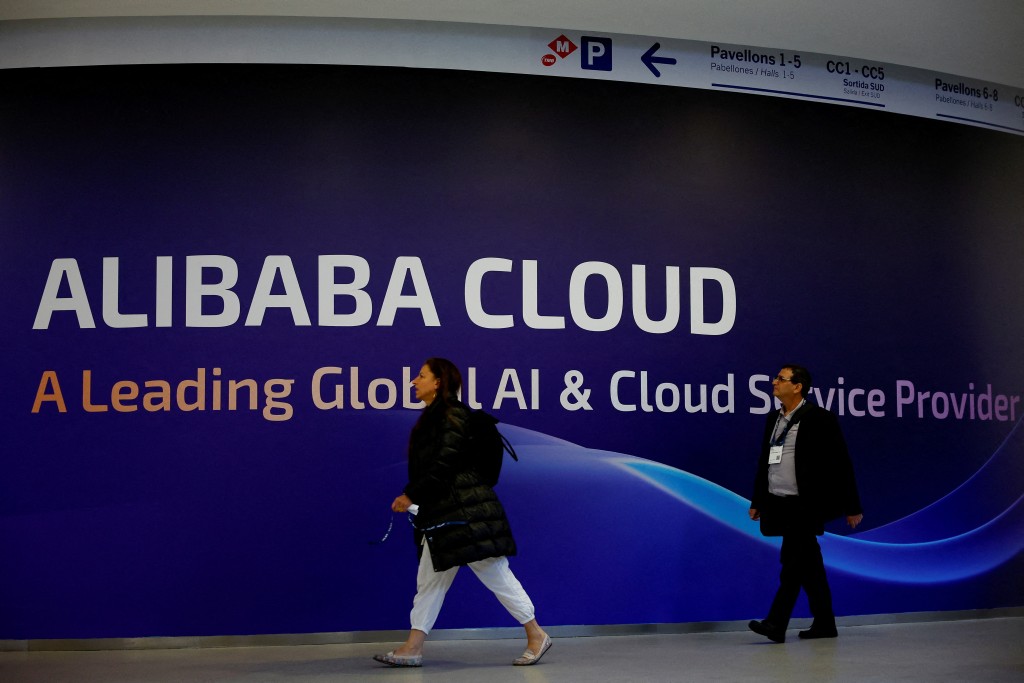 People walk past an Alibaba Cloud sign during the 2025 Mobile World Congress (MWC) in Barcelona, Spain, March 3, 2025. REUTERS