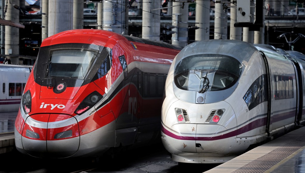High-speed train AVE of the Spanish national railways company RENFE (R) is seen next to high-speed train of private operator Iryo of ILSA company at the Atocha station in Madrid, on February 26, 2023. (AFP/File)