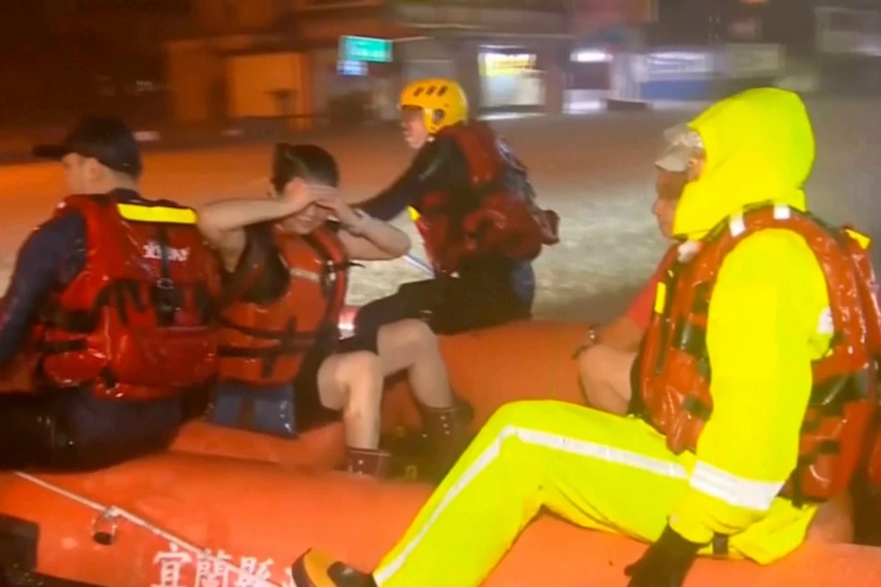 In this image taken from video by Taiwan’s EBC, rescuers evacuate stranded people using an inflatable boat in Yilan County in northeastern Taiwan on Tuesday, Nov. 11. 2025. (EBC via AP )