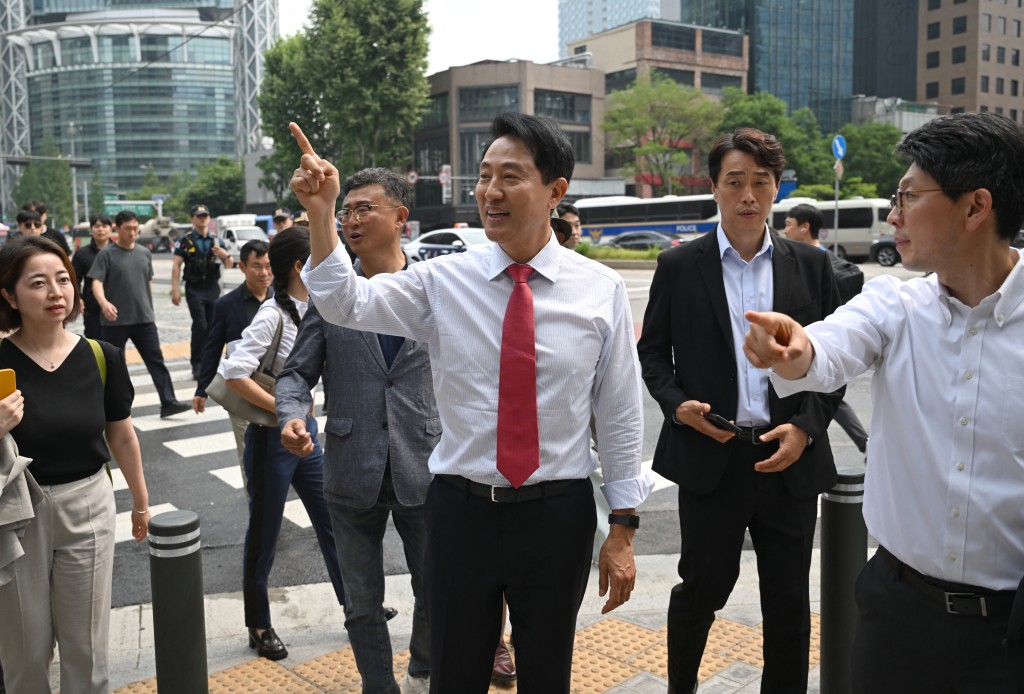 Mayoral candidate Oh Se-hoon (C) of South Korea's main opposition People Power Party greets pedestrians as he walks toward City Hall after national TV predicted his win in the local elections in Seoul on June 4, 2026. (Photo by Jung Yeon-je / AFP)