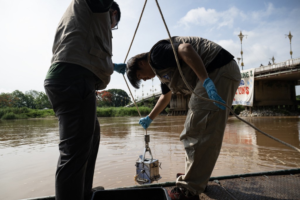 Photo by LILLIAN SUWANRUMPHA / AFP This photo taken on June 5, 2026 shows Wan Wiriya (L), assistant professor from Chiang Mai University, and his colleague collecting a sediment sample from the Kok River near the the northern Thai city of Chiang Rai.