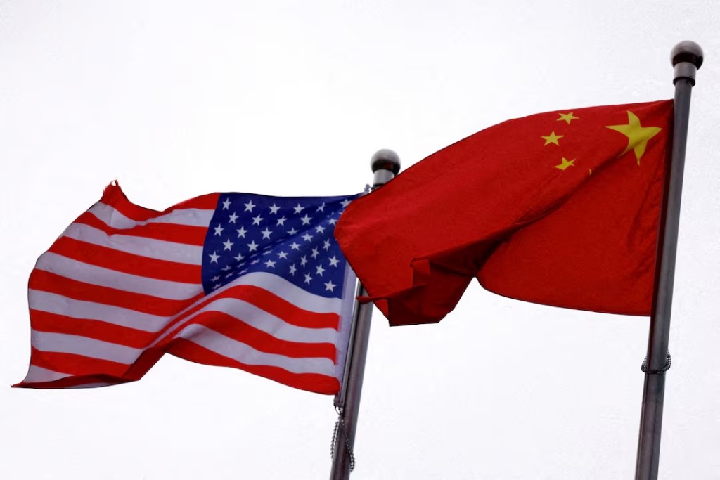 Chinese and U.S. flags flutter outside the building of an American company in Beijing, China April 8, 2025. REUTERS/Tingshu Wang/File Photo 