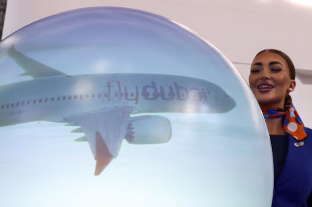 A staff member stands near a "flydubai" display at the Dubai Airshow, in Dubai, United Arab Emirates, November 17, 2025. REUTERS/Amr Alfiky/File Photo 