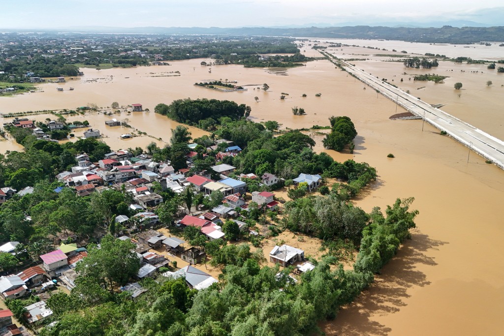 Photo by JOHN DIMAIN / AFP. This photo shows an aerial view of a submerged under construction road with flood waters in Tuguegarao City, Cagayan province, north of Manila on November 11, 2025, as flood waters continue to inundate homes due to heavy rains brought about by Super Typhoon Fung-wong.