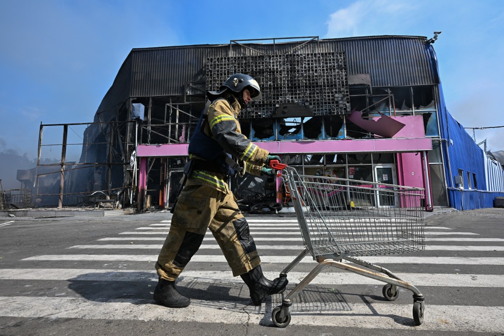 Firefighters work on the grounds of a burned DIY and construction materials mall following an overnight attack, which local Russian-installed officials called Ukrainian drone strikes, in Makiivka (Makeyevka) in the Donetsk region, Russian-controlled Ukraine, on August 10, 2026, amid the ongoing Russian-Ukrainian conflict. (Photo by STRINGER / AFP)