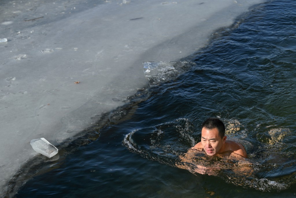Photo by ADEK BERRY / AFP  A winter swimming enthusiast swims at the Houhai Lake of the Shichahai scenic area in Beijing on January 20, 2026.