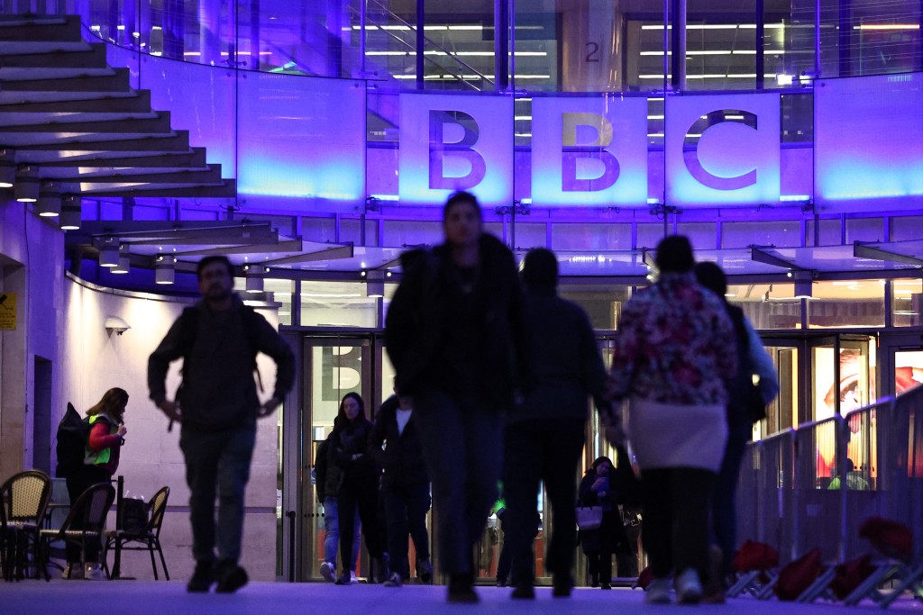 Photo by HENRY NICHOLLS / AFP People use the entrance to the offices of British broadcaster BBC in London in the late afternoon on November 11, 2025.