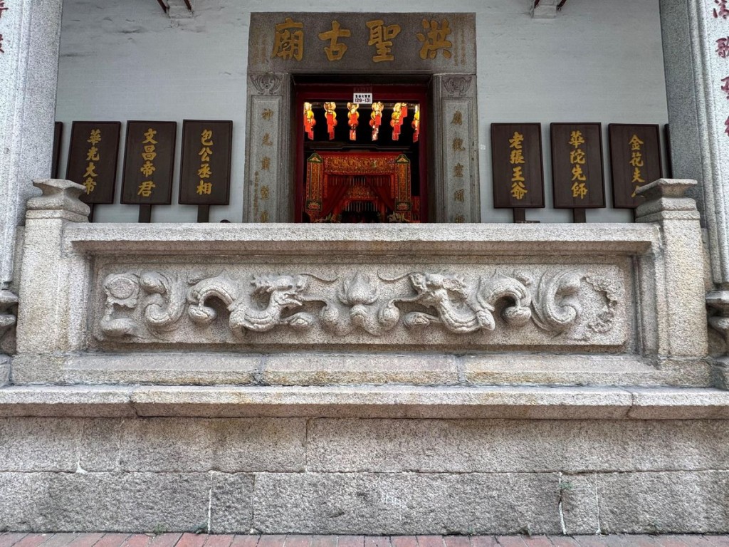 Photo shows the central granite balustrade of the entrance porch, intricately carved with a motif of double dragons and a pearl.