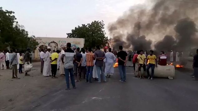 People gather around as smoke and fire are seen on the streets of Kartoum, Sudan, amid reports of a coup, October 25, 2021. People gather around as smoke and fire are seen on the streets of Kartoum, Sudan, amid reports of a coup, October 25, 2021.
