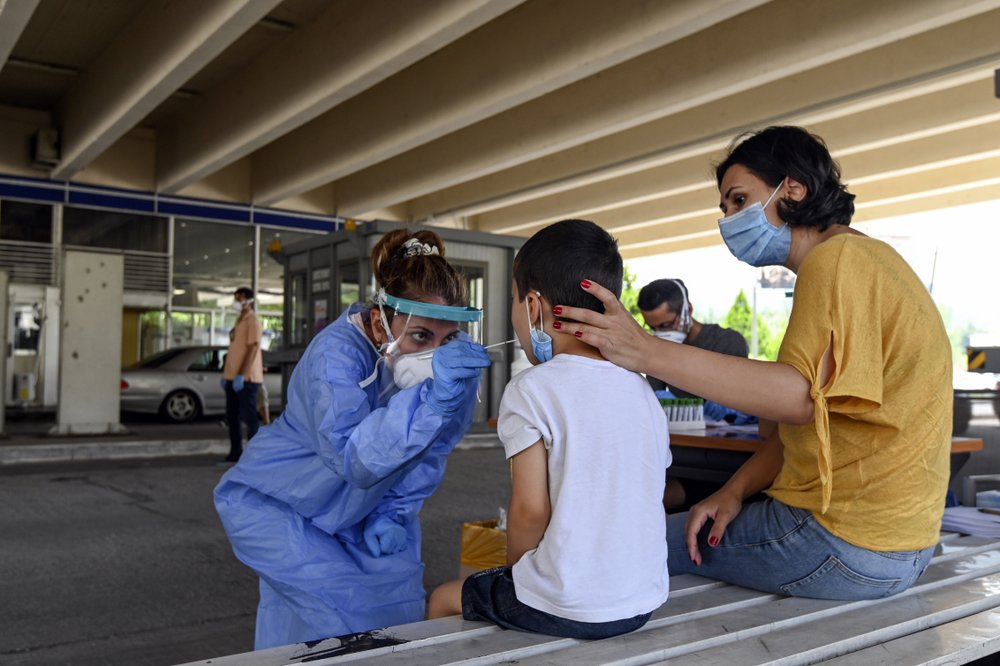A health worker takes swab samples from tourists to test for the coronavirus, at Promahonas border crossing with Bulgaria, which is the only land border into Greece that opened Monday, July 6. A health worker takes swab samples from tourists to test for the coronavirus, at Promahonas border crossing with Bulgaria, which is the only land border into Greece that opened Monday, July 6.