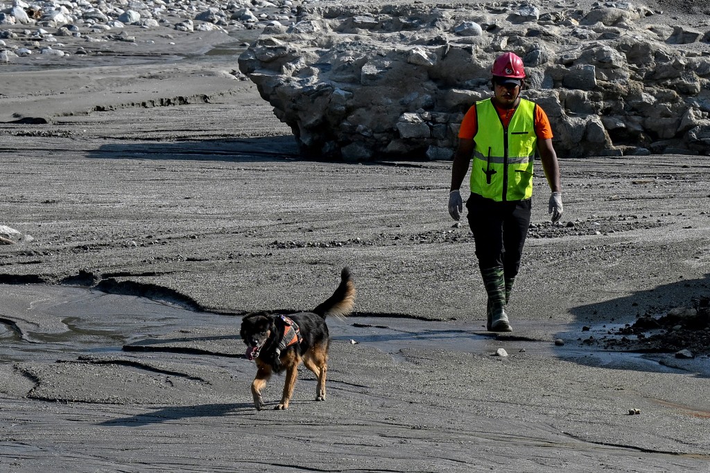 Photo by PRAKASH MATHEMA / AFP A search and rescue team member, along with a sniffer dog, looks for missing people following the August 26 flash flood, on the banks of the Trishuli River in Nepal's Nuwakot district on September 30, 2026.