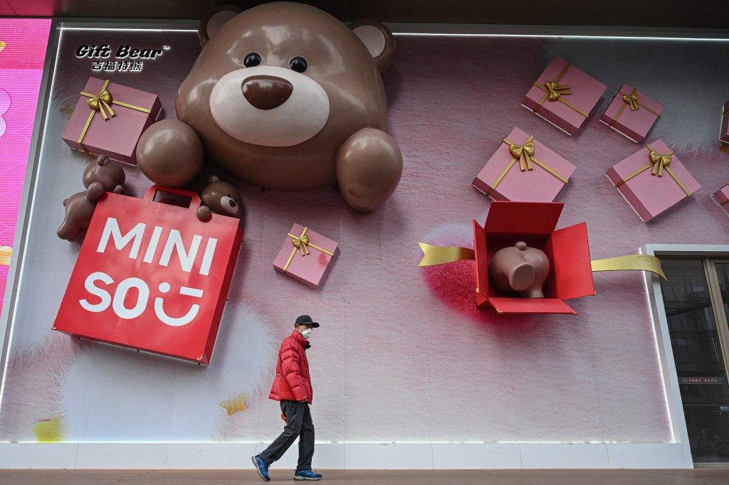 A man walks past a MINISO store in Shanghai on January 9, 2026. (Photo by Jade GAO / AFP)