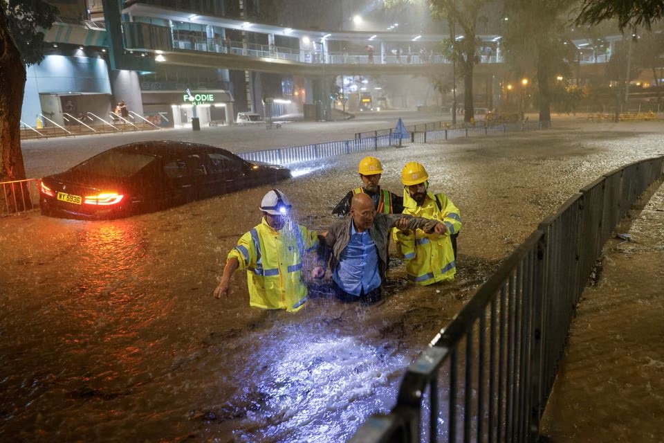 Drainage workers assist a driver stranded due to flooding to a safe place, during heavy rain in Hong Kong. (Reuters) Drainage workers assist a driver stranded due to flooding to a safe place, during heavy rain in Hong Kong. (Reuters)