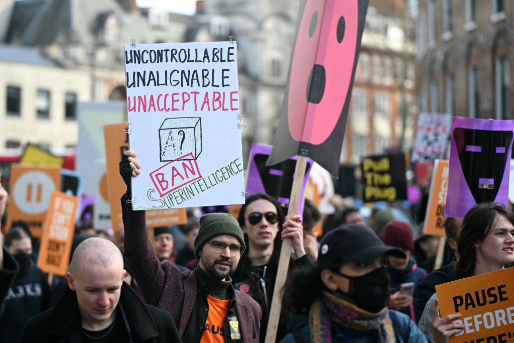 Photo by JUSTIN TALLIS / AFP  Protesters gather with banners and placards at a protest organized by PauseAI UK and other groups concerned in controlling the development of advanced Artificial Intelligence systems, in London on February 28, 2026.