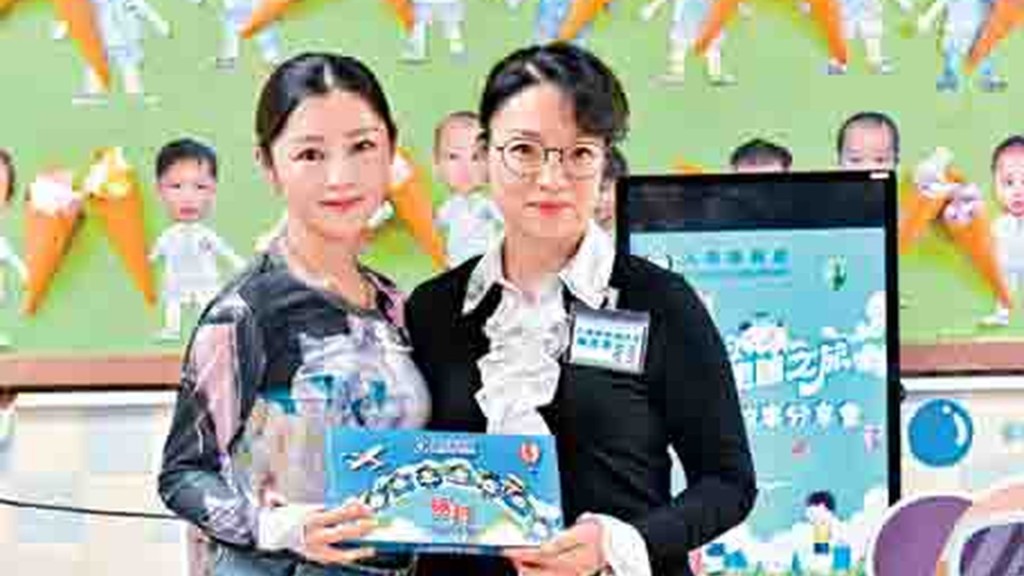 Michelle Wai (left) and Yeung So-ying distribute the story books.