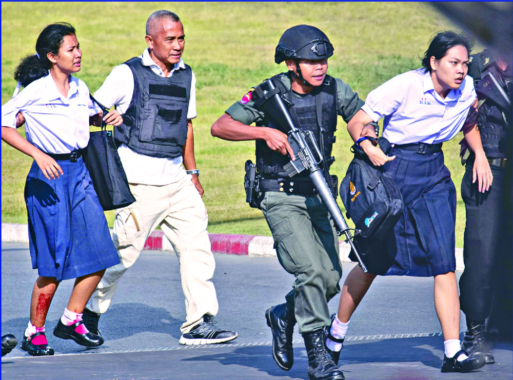 Injured students are rushed away as a relative of one of the victims cries. AP