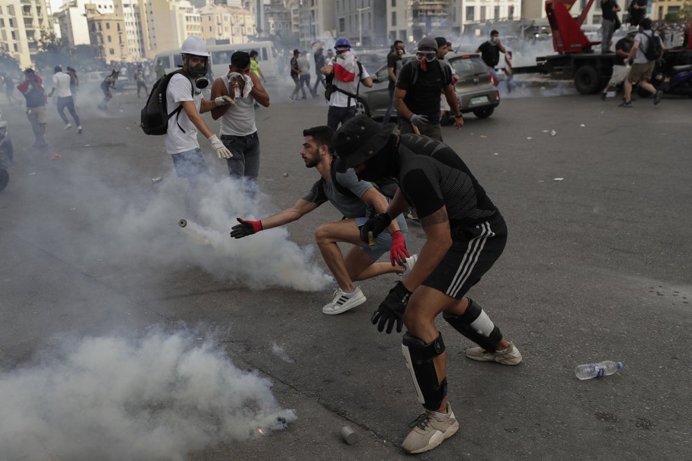 People clash with police during a protest against the political elites and government after this week's deadly explosion at Beirut port which devastated large parts of the capital and killed more than 150 people, in Beirut, Lebanon, Saturday. People clash with police during a protest against the political elites and government after this week's deadly explosion at Beirut port which devastated large parts of the capital and killed more than 150 people, in Beirut, Lebanon, Saturday.