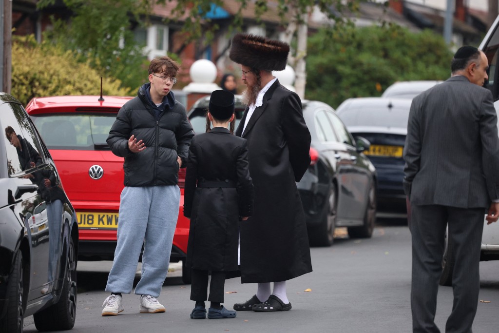 People gather near the scene, after an attack in which a car was driven at pedestrians and stabbings were reported near a synagogue in north Manchester, Britain, October 2, 2025. (Reuters)