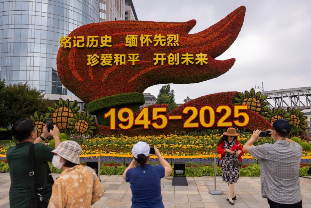  People take images of a flower installation commemorating the 80th anniversary of the end of World War Two, in Beijing, China, August 18, 2025. REUTERS/Maxim Shemetov 
