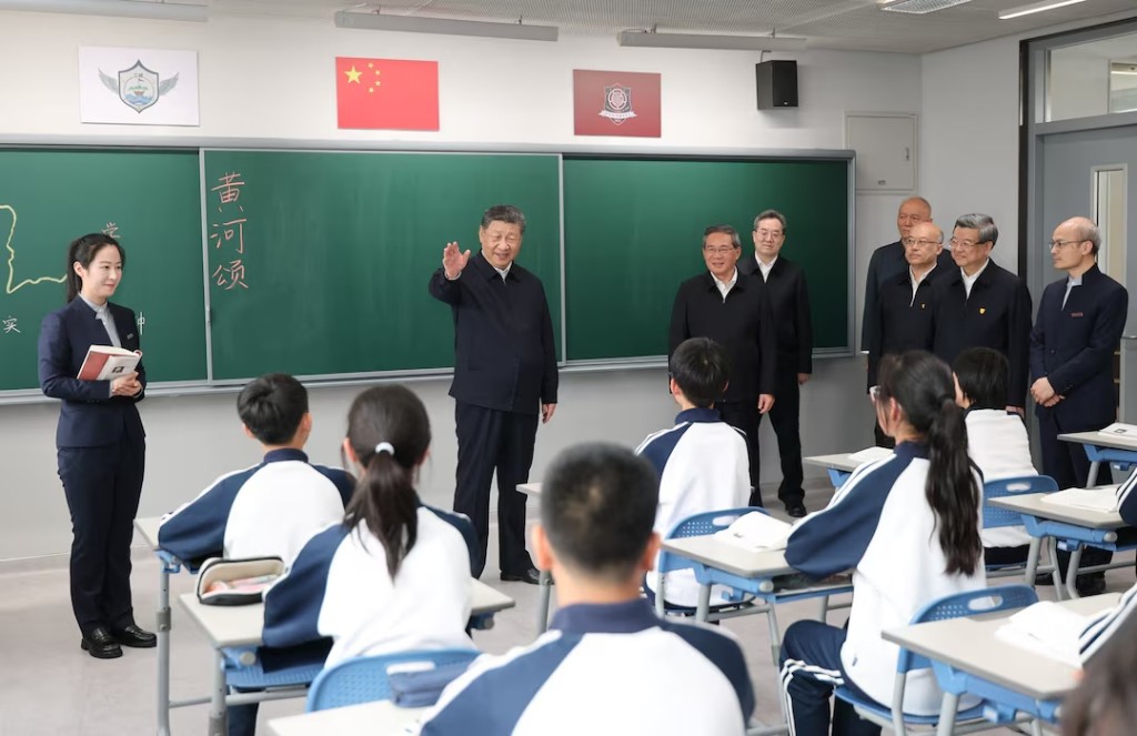 Chinese President Xi Jinping talks with students in a classroom at a high school, during an inspection tour of Xiongan New Area in Hebei province, China March 23, 2026. cnsphoto via REUTERS 