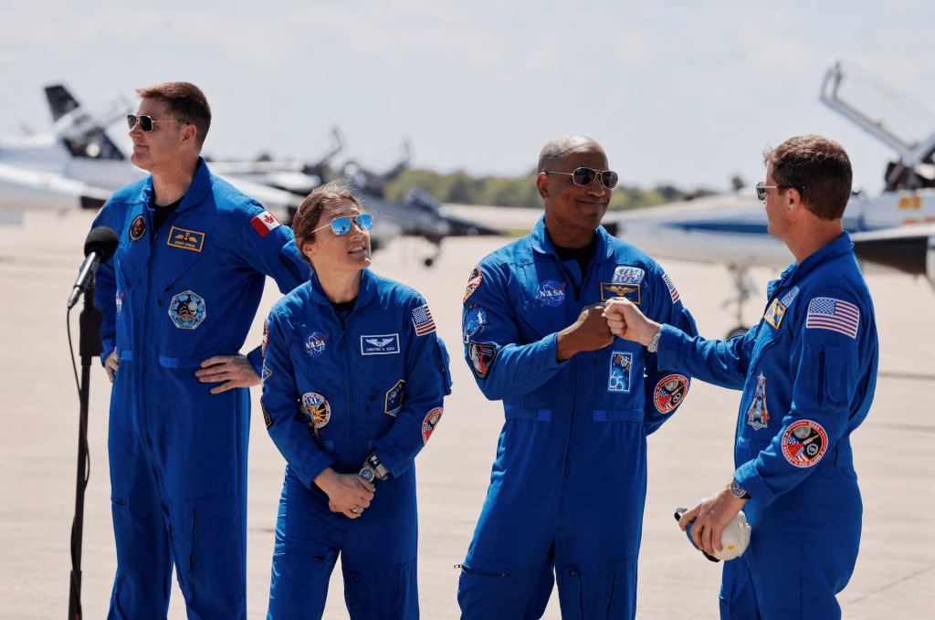 NASA astronauts Reid Wiseman and Victor Glover greet each other next to NASA astronaut Christina Koch and CSA (Canadian Space Agency) astronaut Jeremy Hansen, at Kennedy Space Centre, ahead of the Artemis II launch in Cape Canaveral, Florida, U.S., March 27, 2026. REUTERS/Joe Skipper