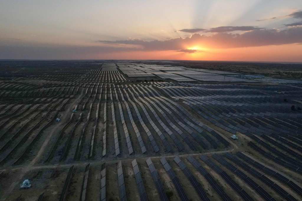 This picture taken on August 11, 2025 shows the sun setting over solar panels deployed at the Kubuqi Photovoltaic Desert Control Project, near Ordos, in China northern Inner Mongolia, region. AFP